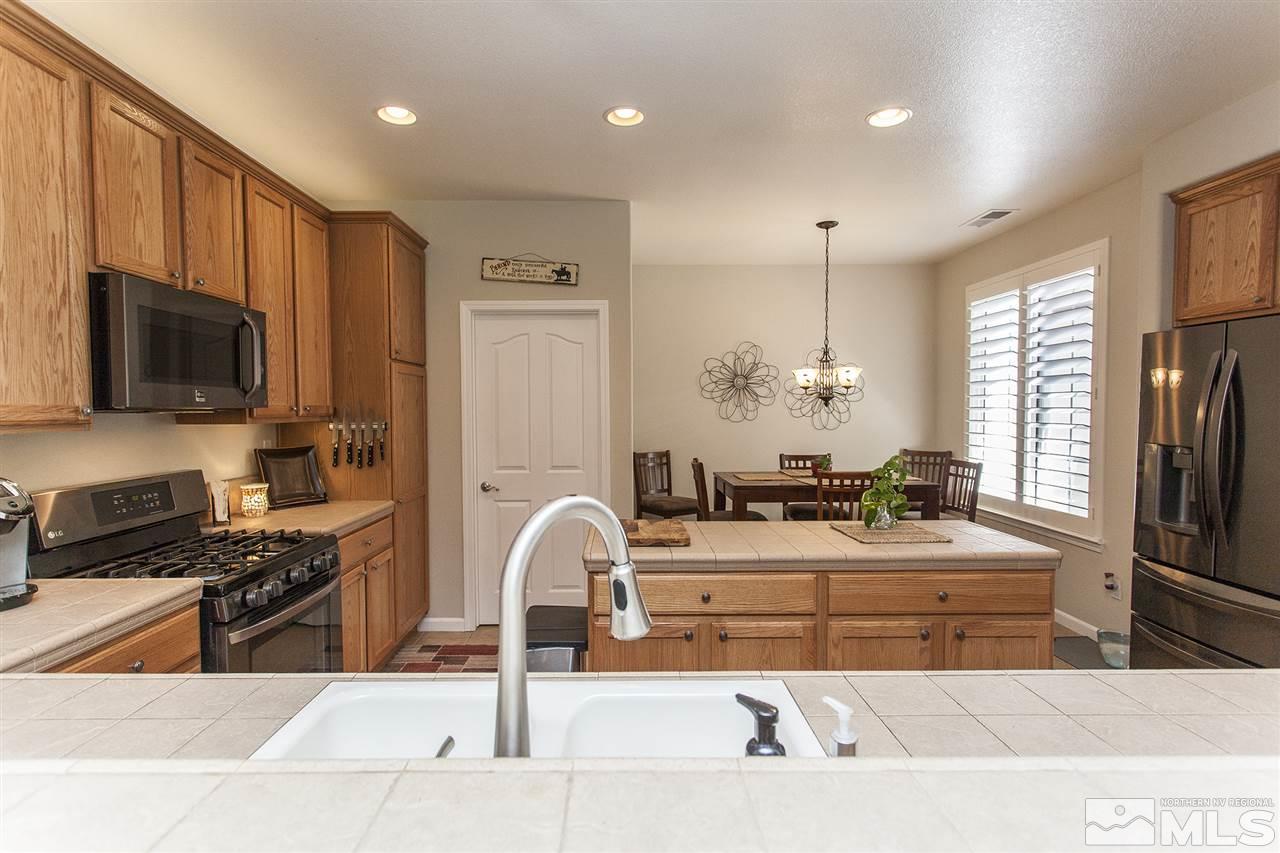 470 Sysonby Court Reno, NV 89521 - Photo 10 of 36 a kitchen with stainless steel appliances kitchen island granite countertop a sink and a stove