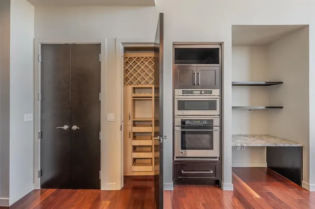 a kitchen with wooden floor and electronic appliances
