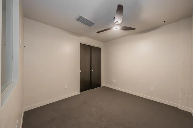 an empty room with a ceiling fan and wooden floor