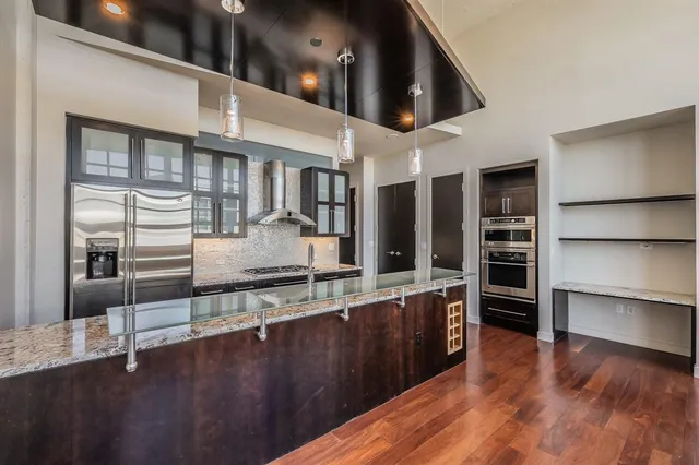 a large kitchen with stainless steel appliances wooden floors and view