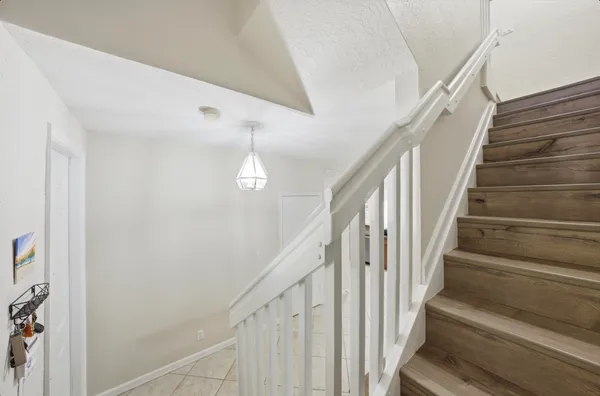 a view of staircase with railing and white walls