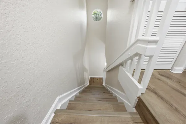 a view of staircase with white walls and a window