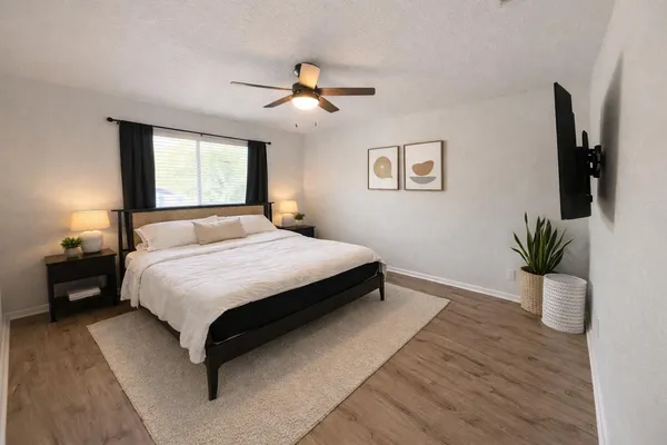a bedroom with a large bed and a chandelier