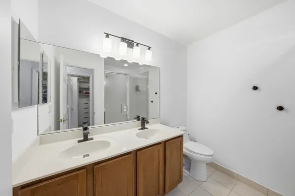 a bathroom with a double vanity sink toilet and mirror