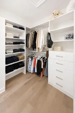 a view of walk in closet with clothes and shoes
