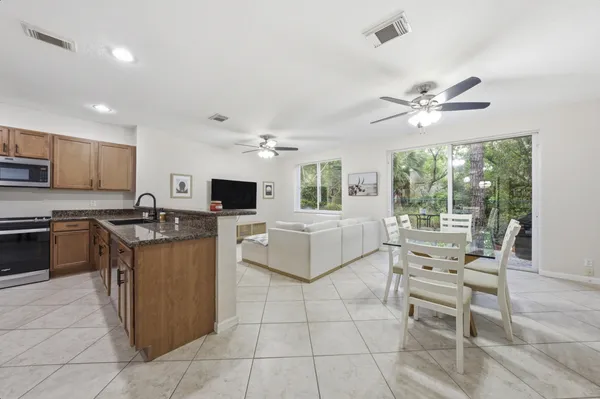 a living room with furniture a flat screen tv and a view of kitchen