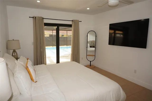 a bedroom with a bed and a flat tv screen on dresser