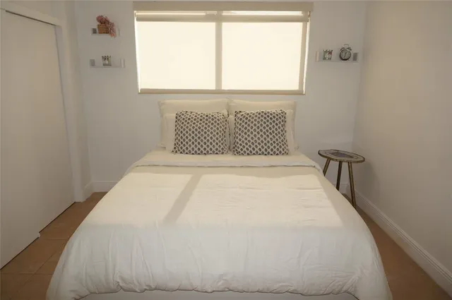 a large bed sitting in a bedroom next to a window