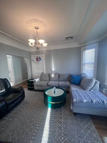 a living room with furniture a flat screen tv and kitchen view