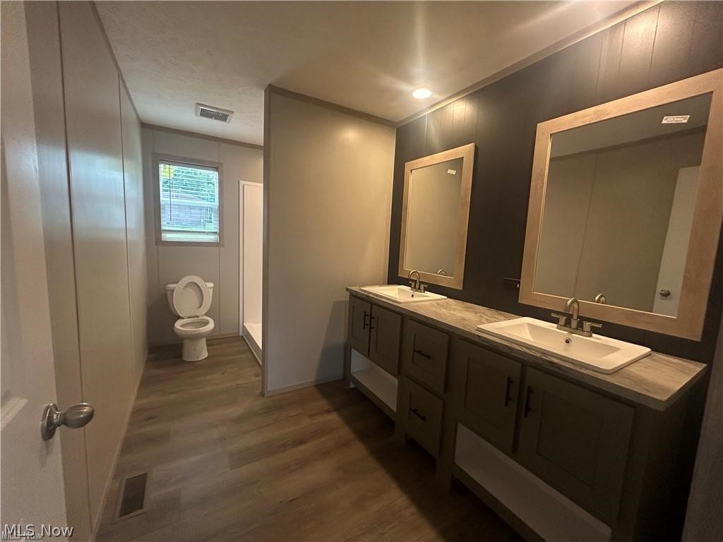 252 Front Street Philo, OH 43771 - Photo 9 of 17 Full bath with double vanity, dark wood-type flooring, and a stall shower