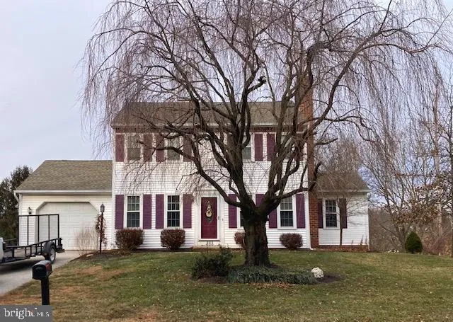 a front view of a house with a yard covered with snow