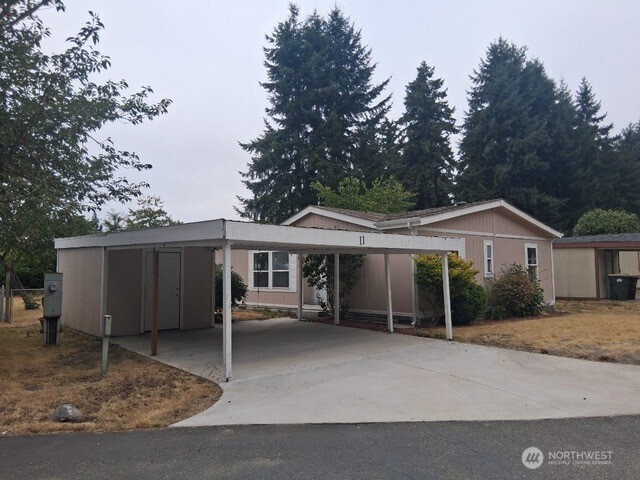 915 Union Mills Road Southeast, Unit 11 Lacey, WA 98503 - Photo 2 of 15 a view of house with a yard and large tree