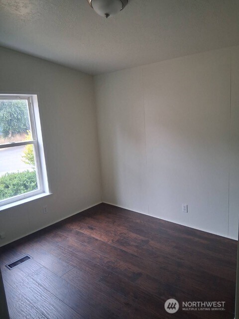 915 Union Mills Road Southeast, Unit 11 Lacey, WA 98503 - Photo 8 of 15 an empty room with wooden floor and windows