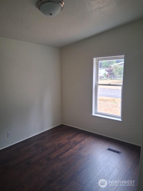 915 Union Mills Road Southeast, Unit 11 Lacey, WA 98503 - Photo 9 of 15 an empty room with wooden floor and windows