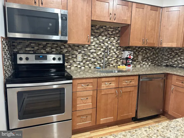 a kitchen with granite countertop cabinets and steel stainless steel appliances