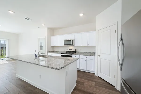 a kitchen with stainless steel appliances granite countertop a stove a sink and a refrigerator