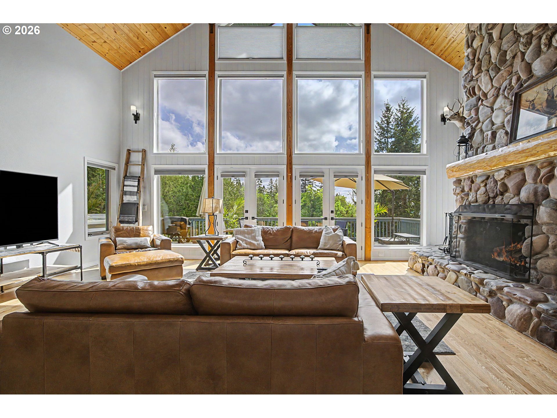23303 Southeast Howlett Road Eagle Creek, OR 97022 - Photo 13 of 48 a living room with furniture a flat screen tv and a large window