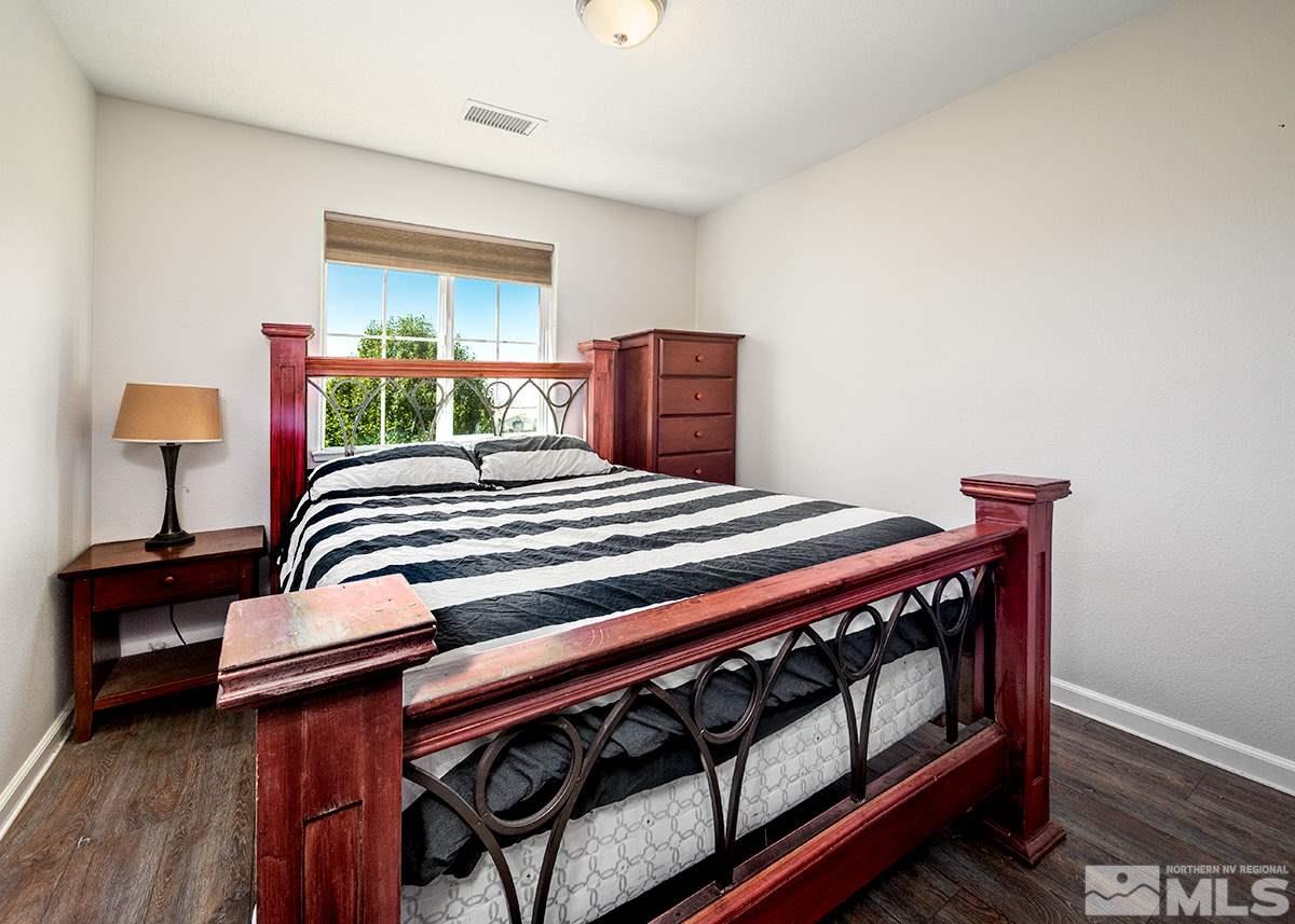 590 Verelli Court Reno, NV 89521 - Photo 13 of 23 a bedroom with a bed wooden floor and lamp