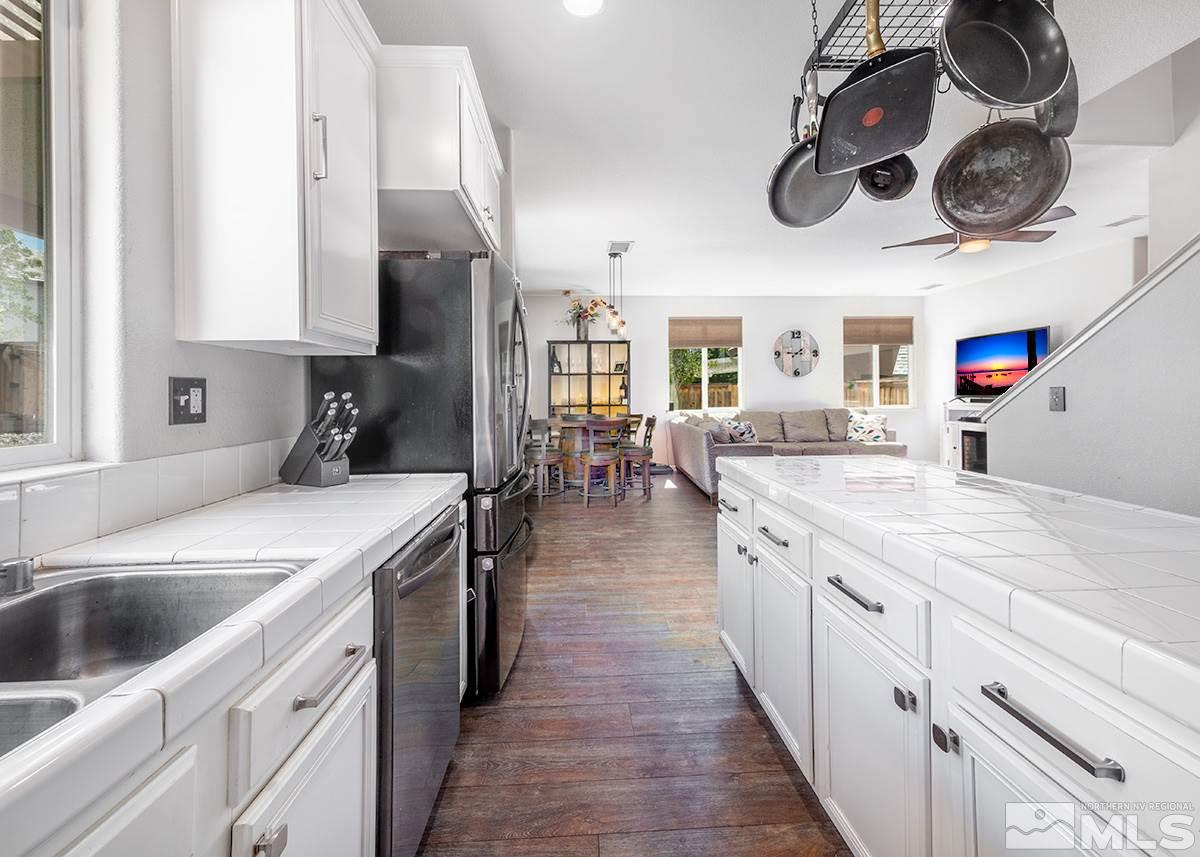 590 Verelli Court Reno, NV 89521 - Photo 6 of 23 a kitchen with a stove oven a sink dishwasher and white cabinets with wooden floor