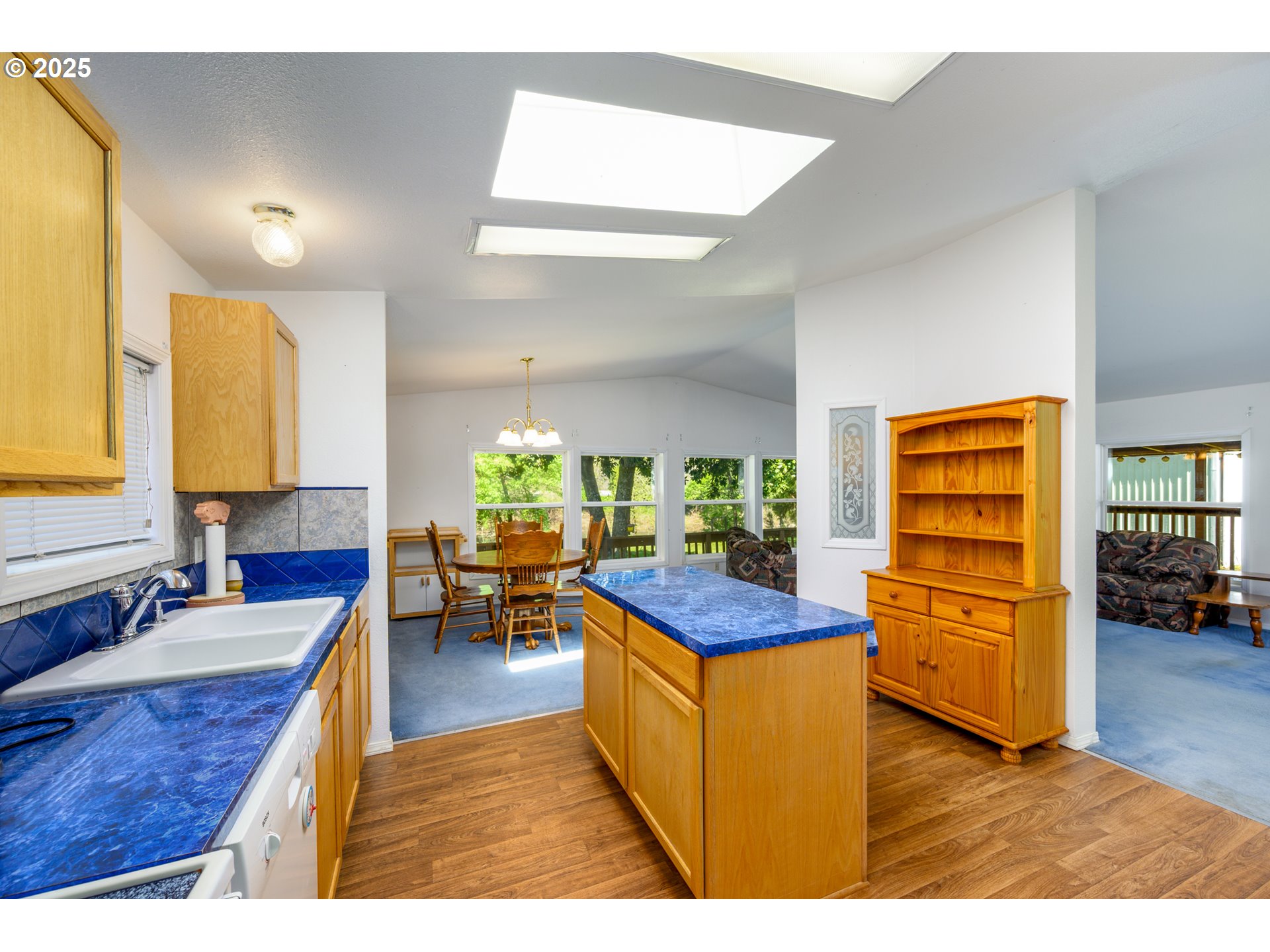 694 Tipton Road Roseburg, OR 97471 - Photo 11 of 36 a kitchen that has a lot of cabinets a sink and wooden floor
