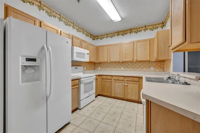 a kitchen with stainless steel appliances granite countertop a refrigerator sink and stove