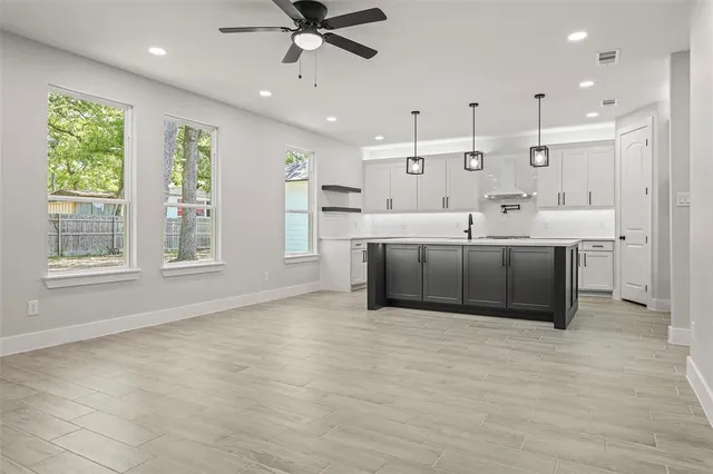 a large room with stainless steel appliances kitchen island granite countertop a sink and cabinets