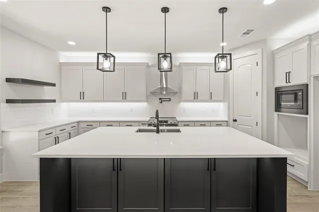 a kitchen with a sink a stove and chairs