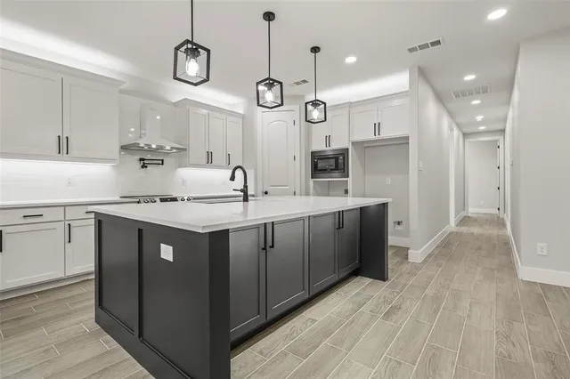 a kitchen with a sink cabinets and wooden floor