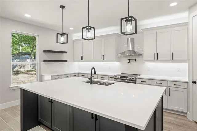 a kitchen with kitchen island stainless steel appliances a stove a sink a center island a stove and a center island