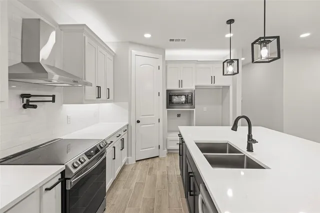 a kitchen with granite countertop a sink and refrigerator