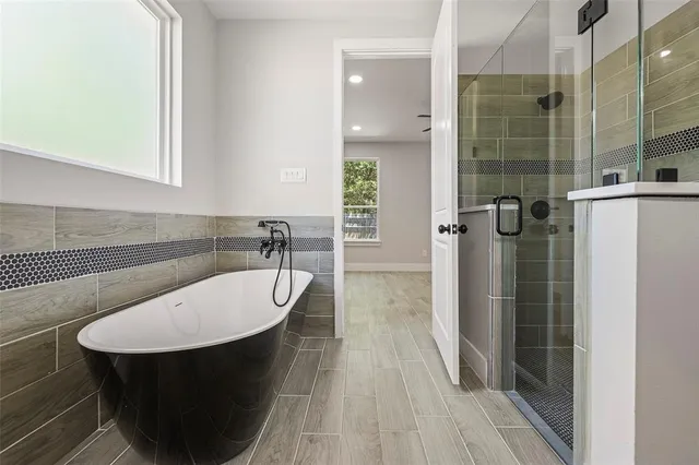 a bathroom with a sink a shower a mirror and a bathtub