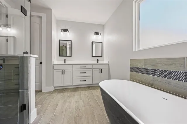 a spacious bathroom with a bathtub sink and mirror