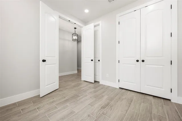a view of a hallway with wooden floor and white doors