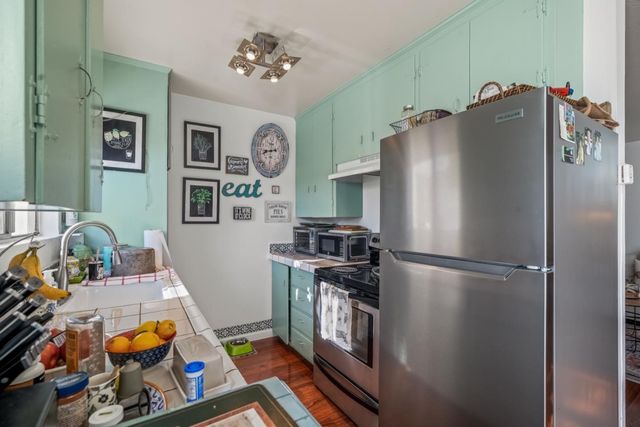 a kitchen with stainless steel appliances granite countertop a refrigerator a stove and a sink with dishwasher