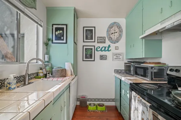 a bathroom with a stove a sink and a mirror