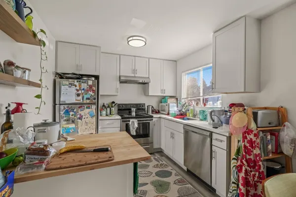 a kitchen with a stove a sink and cabinets