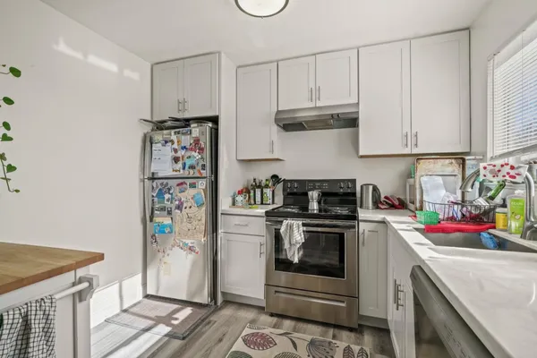 a kitchen with stainless steel appliances granite countertop a refrigerator sink and stove