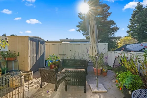 a view of a patio with couches table and chairs and potted plants