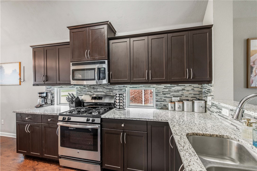 3014 Positano Loop Bryan, TX 77808 - Photo 12 of 23 a kitchen with granite countertop a sink stove and microwave