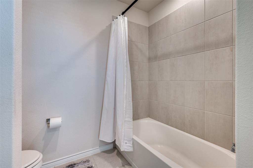 3876 Lyndhurst Avenue Little Elm, TX 75068 - Photo 21 of 25 a bathroom with a bathtub and a toilet