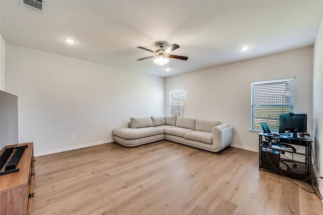 a living room with furniture and a wooden floor