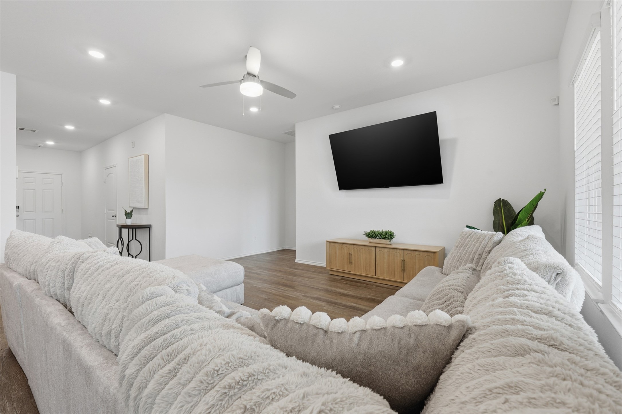 17719 Winfall Drive Crosby, TX 77532 - Photo 11 of 47 This living room has modern recessed lighting, a ceiling fan, and warm flooring, creating an inviting and comfortable ambiance.