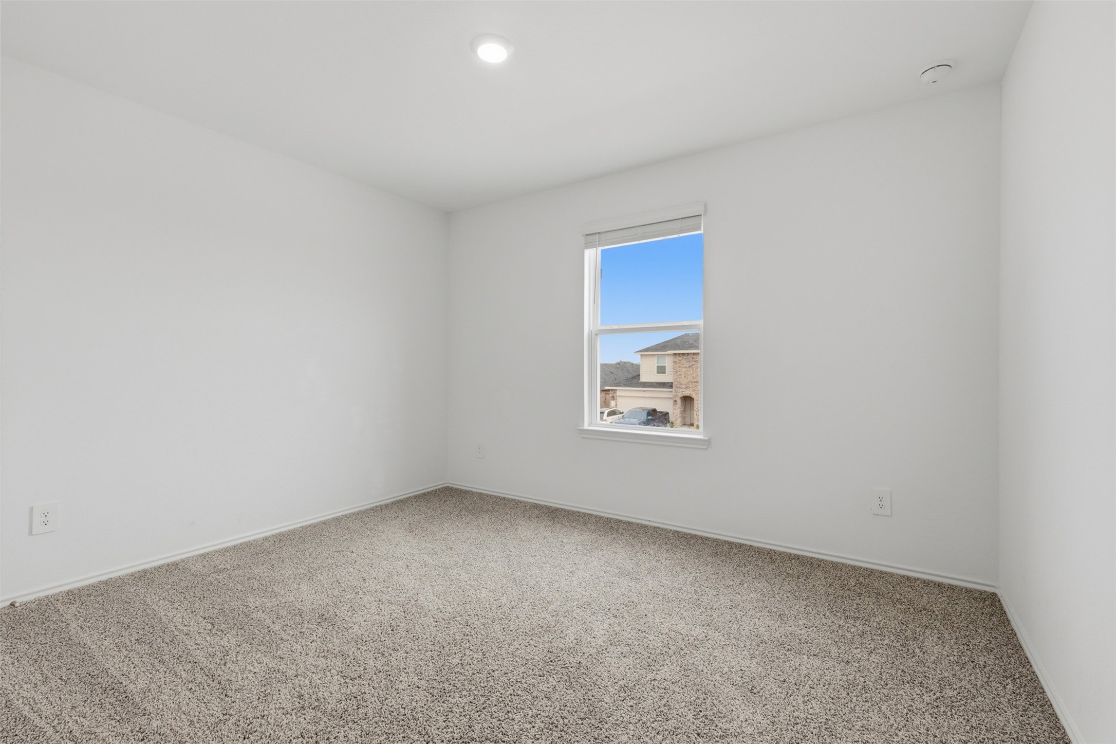 17719 Winfall Drive Crosby, TX 77532 - Photo 35 of 47 A bright fourth bedroom with neutral walls and carpeted flooring, featuring a single window with a view of neighboring houses.