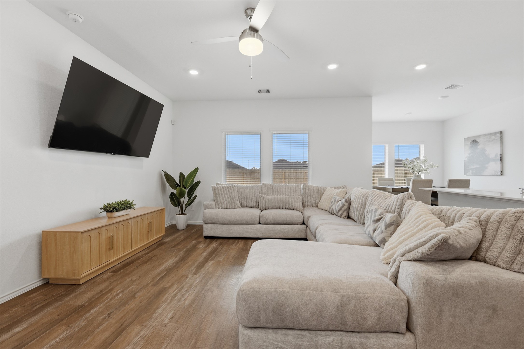 17719 Winfall Drive Crosby, TX 77532 - Photo 9 of 47 Natural light streams through the windows, and the open layout connects to a dining area. A ceiling fan and recessed lighting add modern touches.