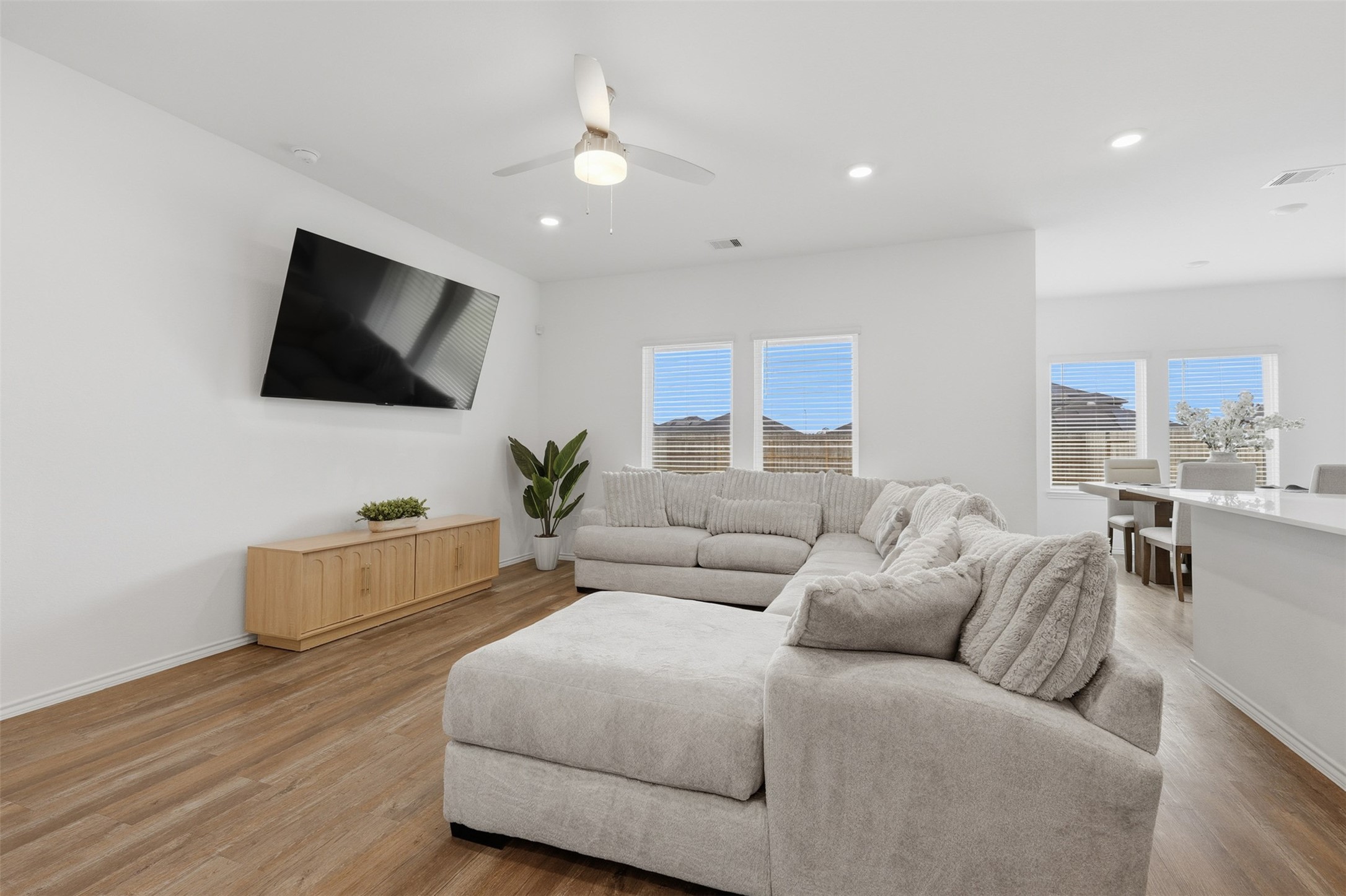 17719 Winfall Drive Crosby, TX 77532 - Photo 10 of 47 Bright, open living space. The room features a ceiling fan, ample natural light from multiple windows, and a view into the dining area.