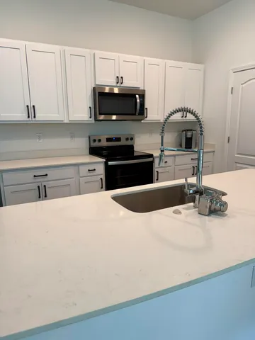 a kitchen with granite countertop a stove and a sink
