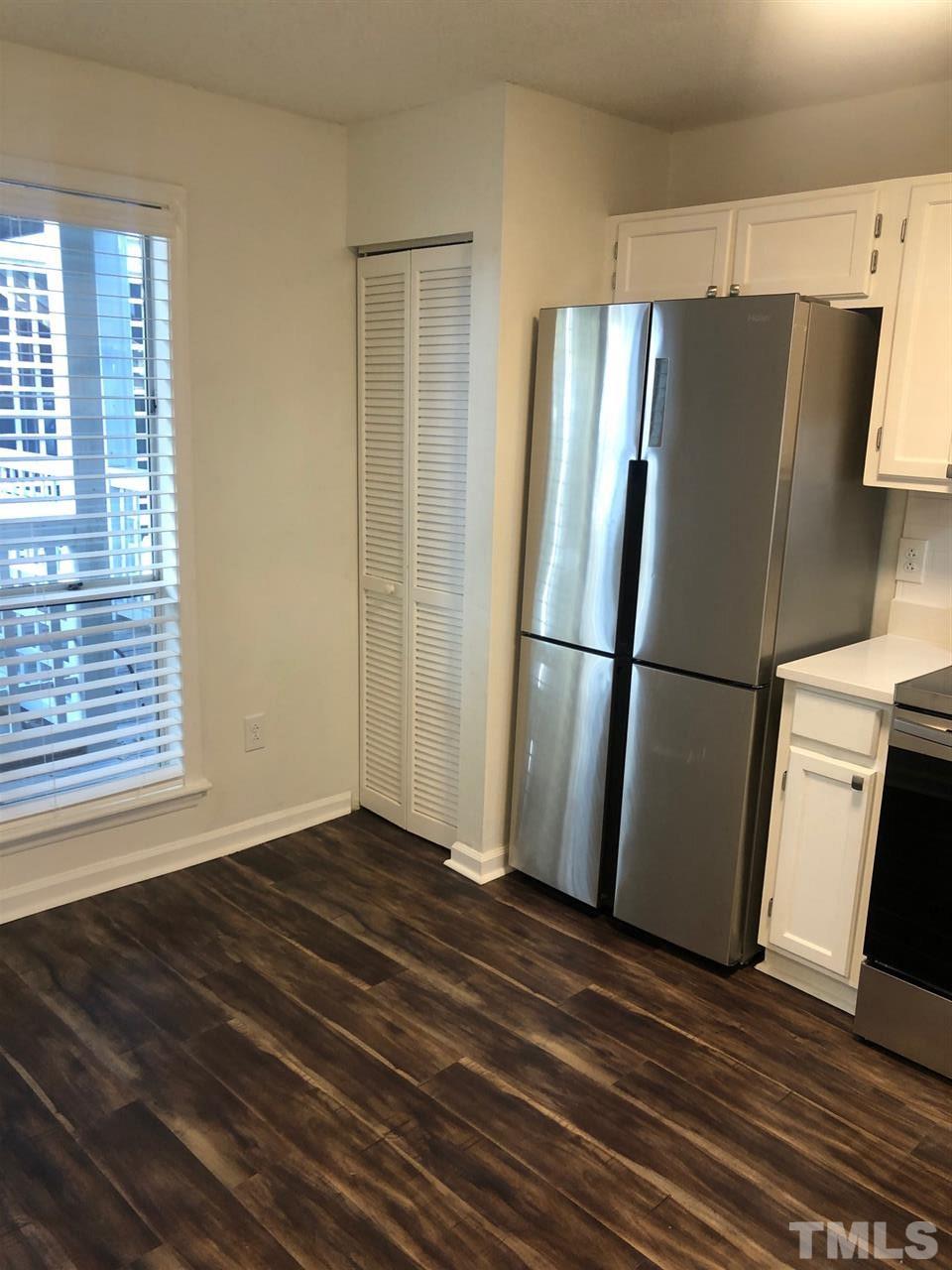 4621 Timbermill Court, Unit 103 Raleigh, NC 27612 - Photo 4 of 13 a view of a refrigerator in kitchen and wooden floor