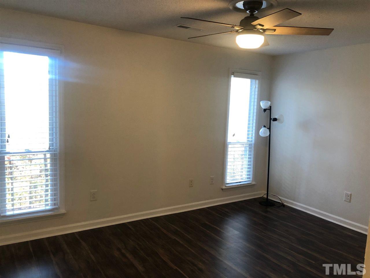 4621 Timbermill Court, Unit 103 Raleigh, NC 27612 - Photo 7 of 13 an empty room with wooden floor and windows