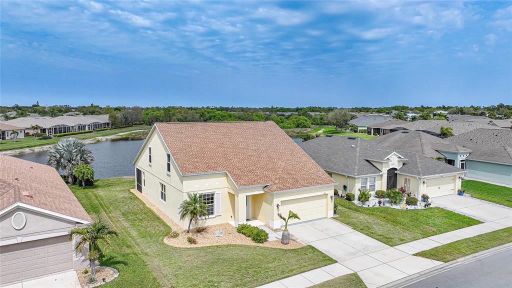 an aerial view of a house with a garden and lake view