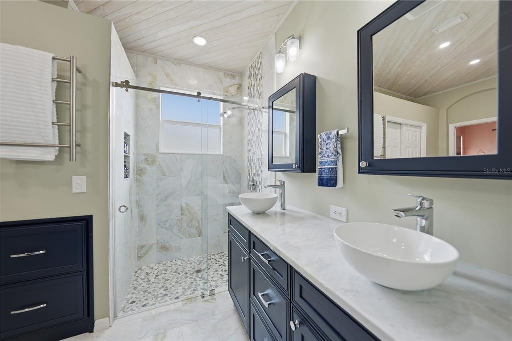 5221 Layton Drive Venice, FL 34293 - Photo 18 of 33 a bathroom with a double vanity sink mirror and shower